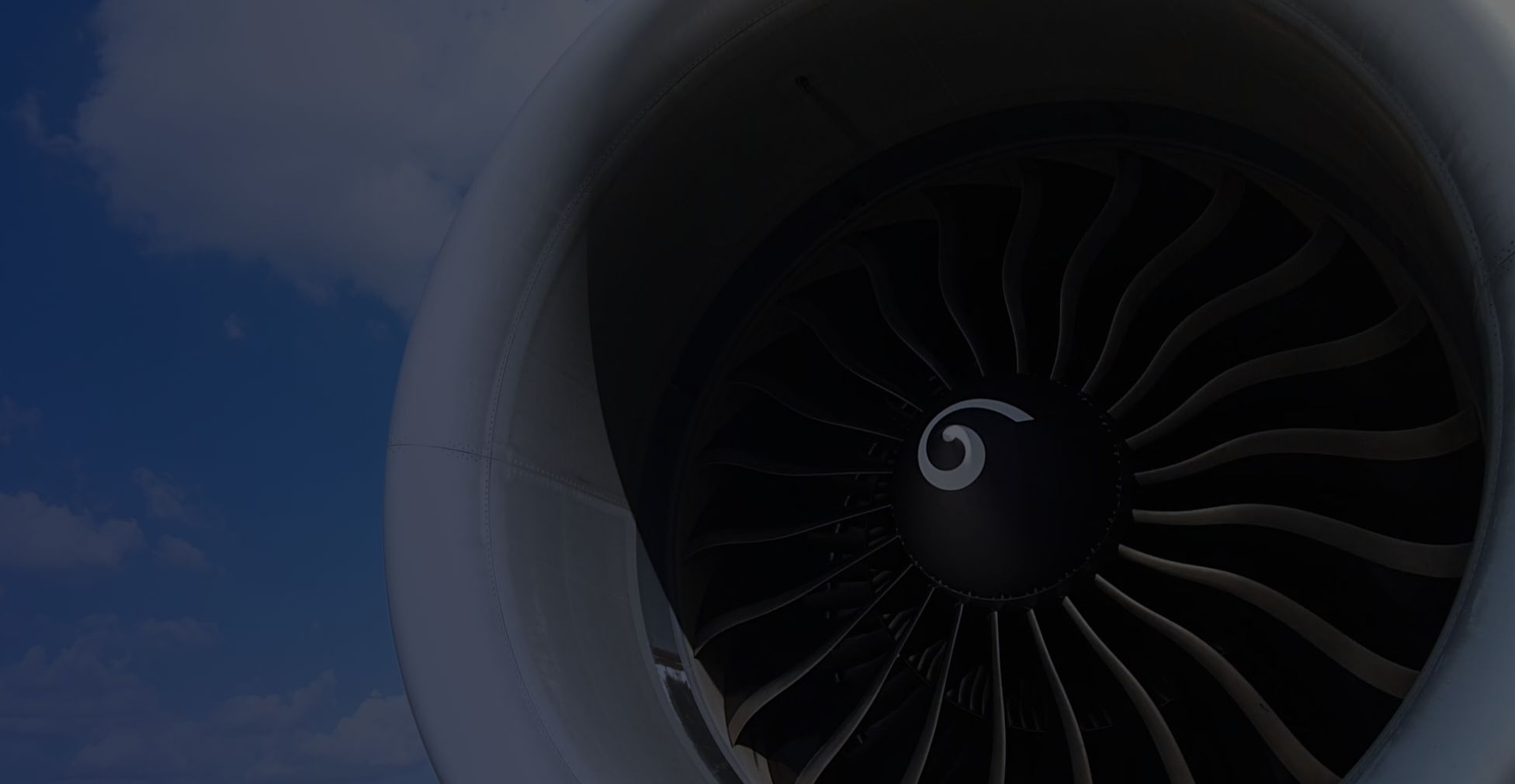 Close-up view of a jet engine with a blue sky background.